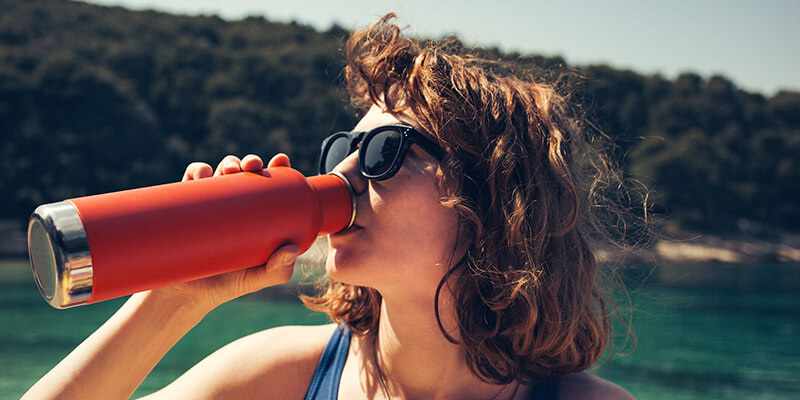 Woman Drinking Water At The Beach